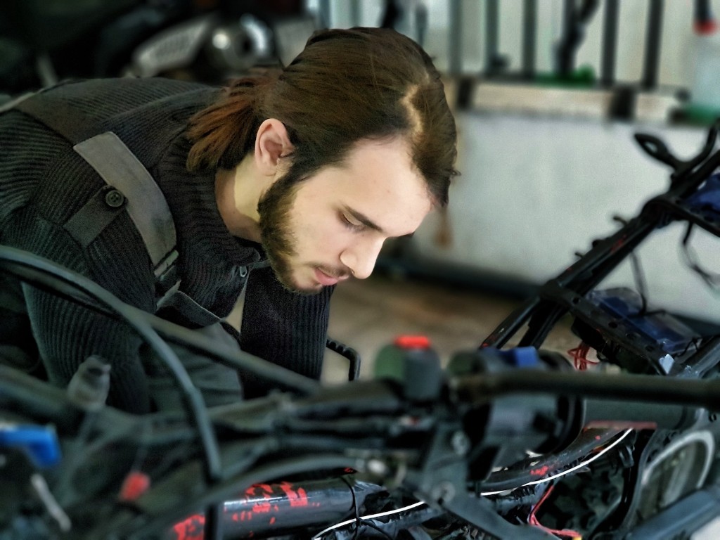 Petros working on a motorcycle in the workshop